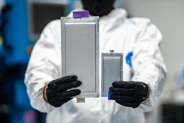 worker holding up examples of patented solid-state batteries