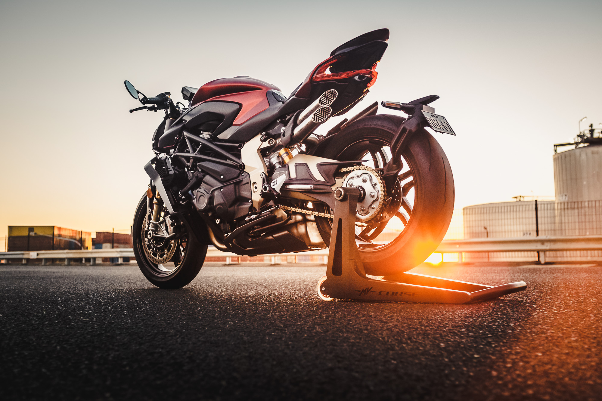 A MV Agusta Brutale motorcycle on an industrial road at sunset