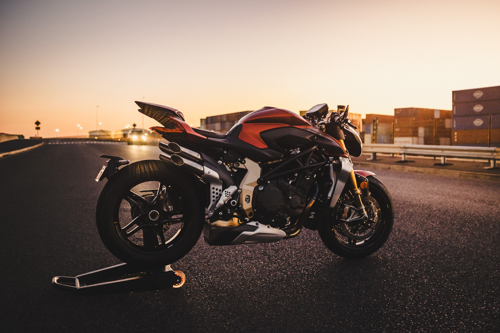 An MV Agusta Brutale motorcycle on an industrial road at sunset