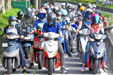 a group of riders in Taiwan waiting for the light to change