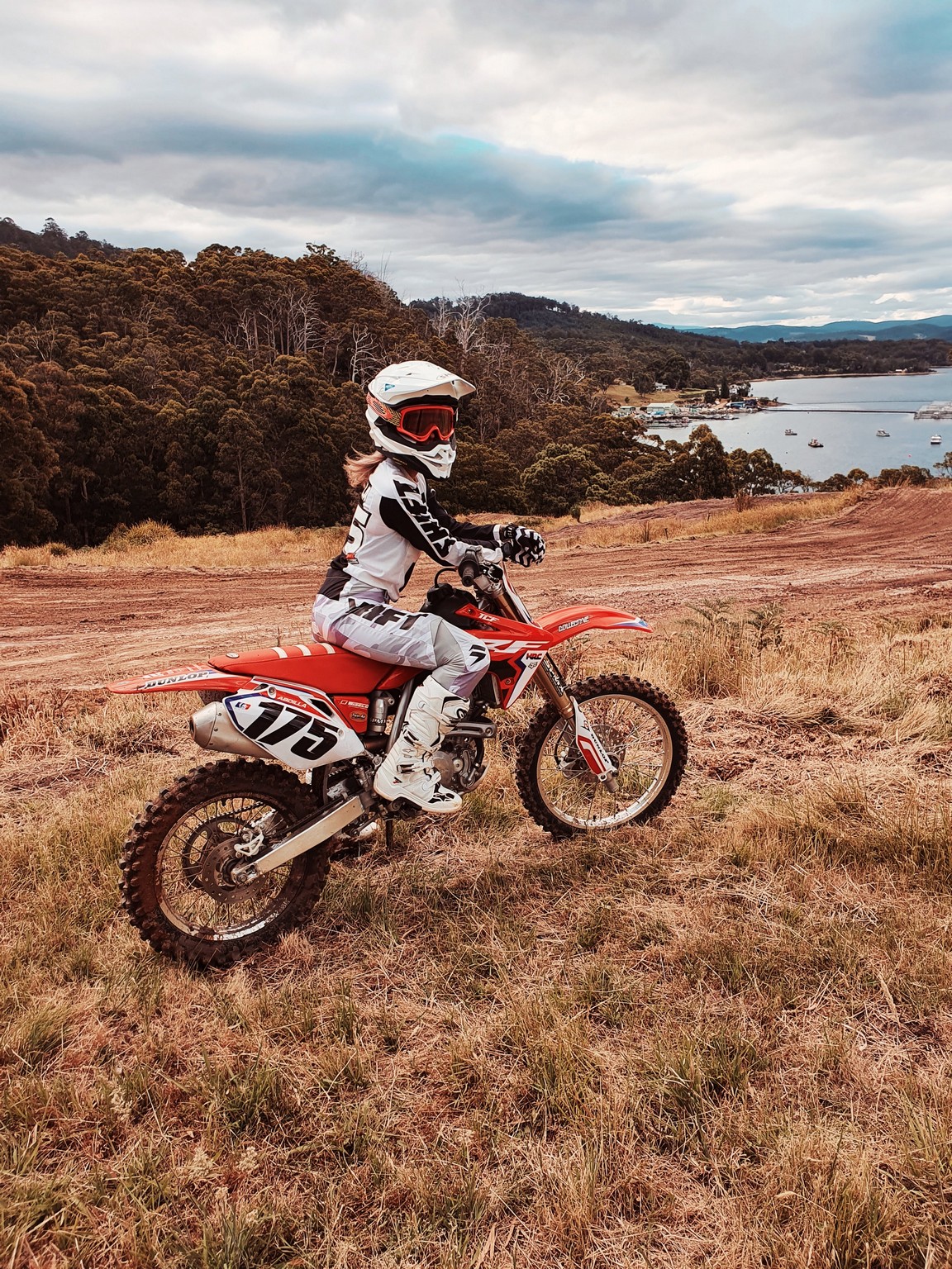 Woman on a motocross motorcycle at dusk in a Tasmanian field