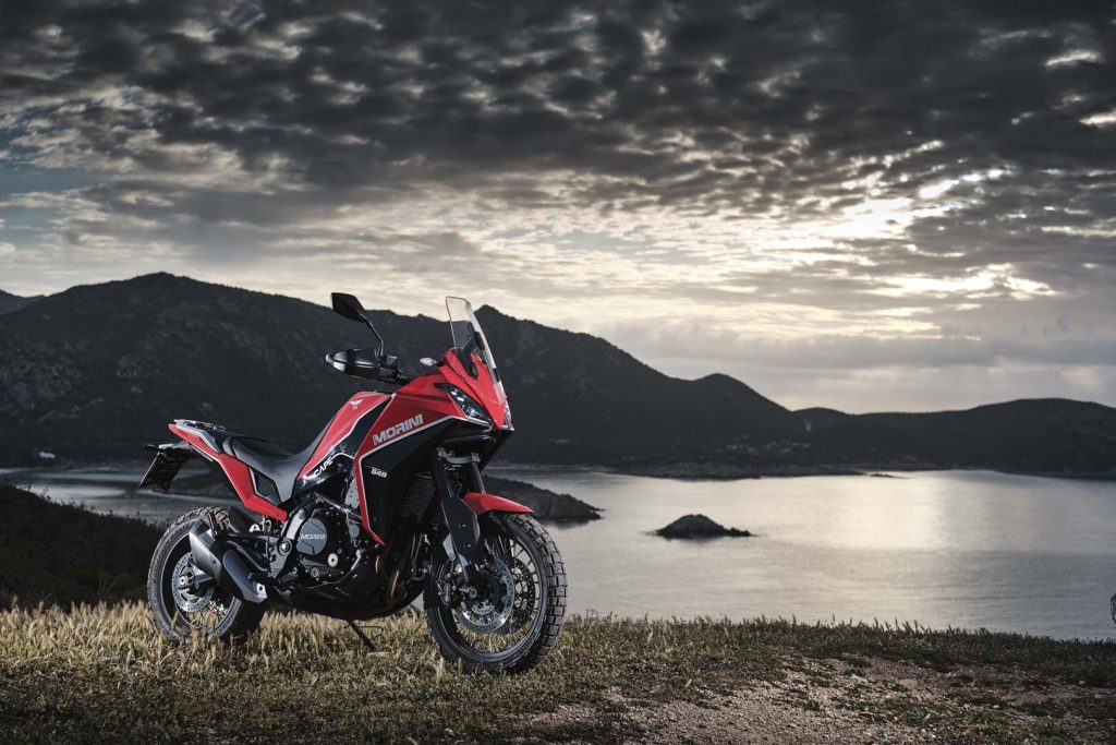 A view of a rider trying out the all-new Moto Morini X-Cape adventure motorbike on rugged terrain, with a gorgeous tropical view.