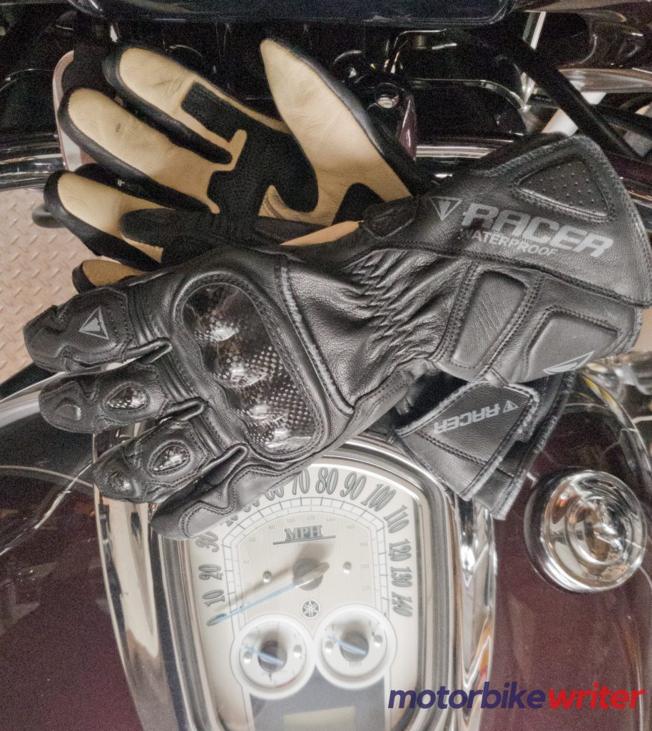 Racer Multitop 2 Waterproof Gloves crisscrossed on black motorcycle fuel tank
