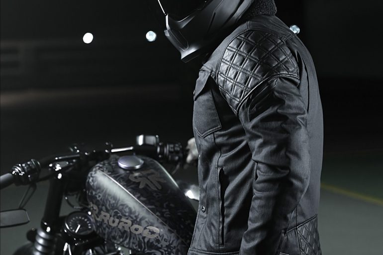 A view of a model wearing the Mother Trucker jacket from Enginehawk and featuring a Ruroc helmet
