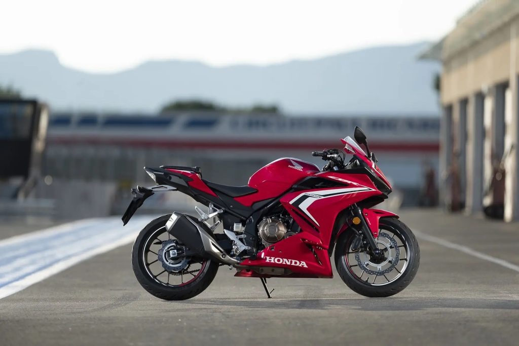 A Honda CBR500R against pavement and a building